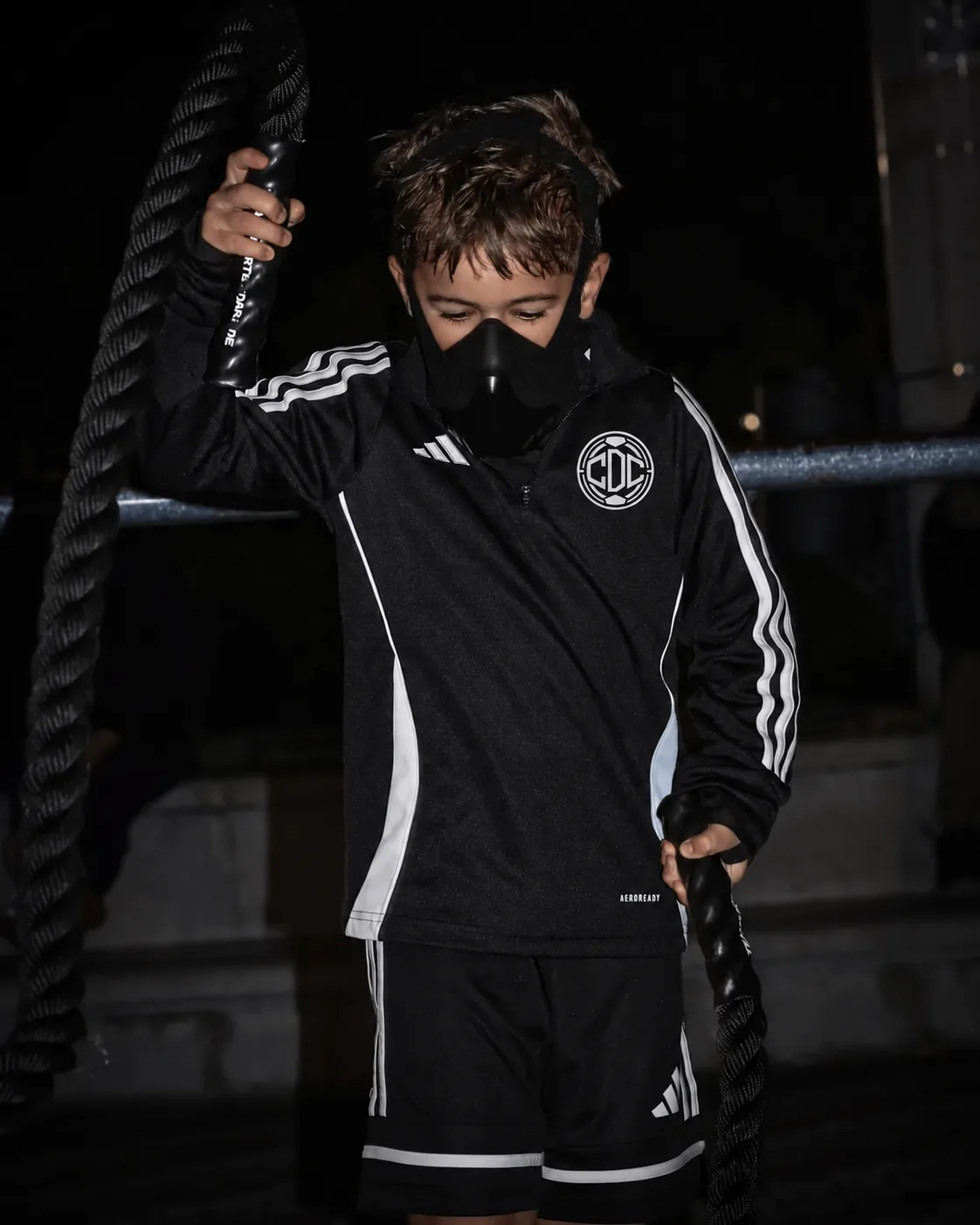 A CDC player working with battle ropes in a night strength session