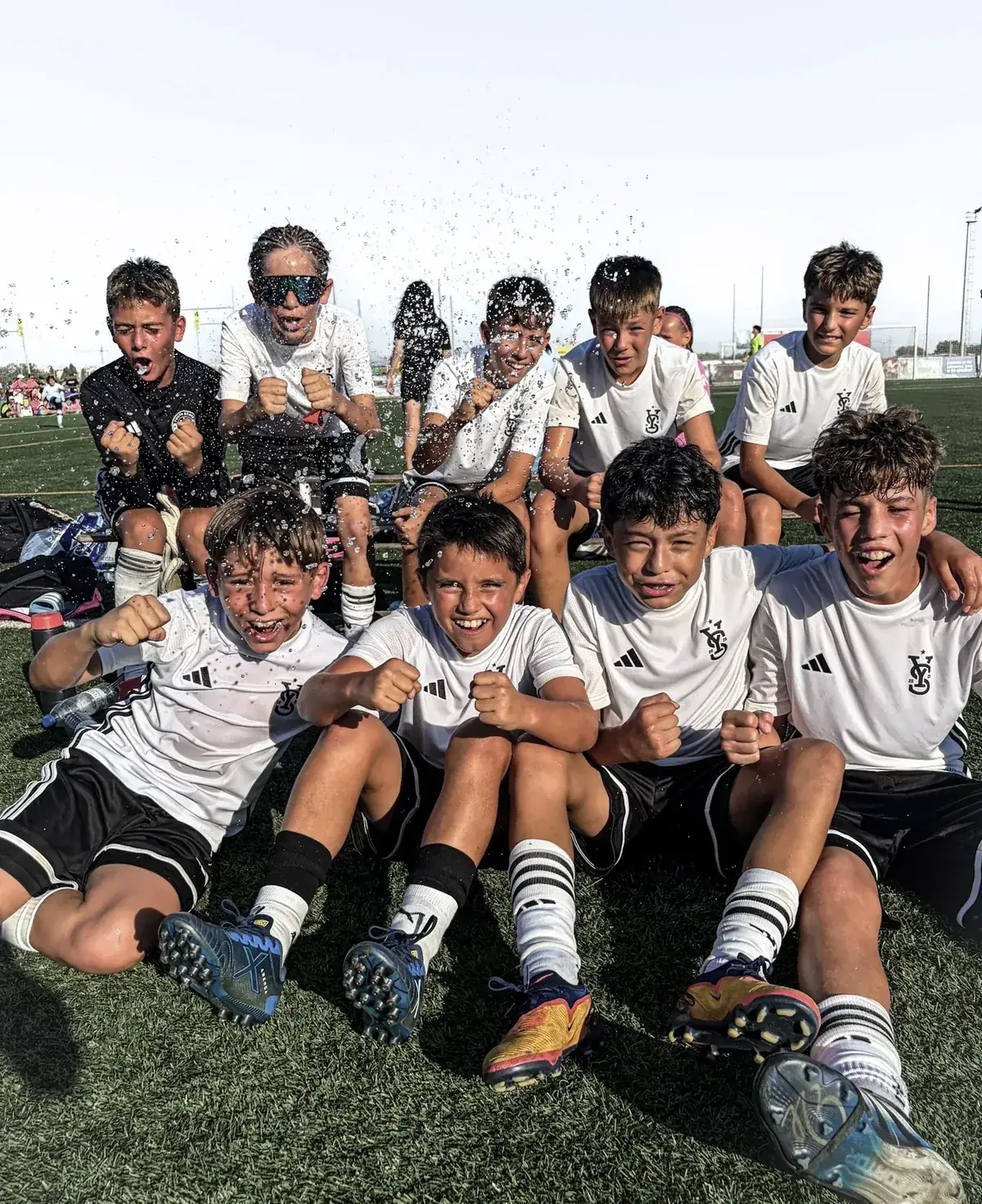 A CDC squad celebrating together on the pitch after a match