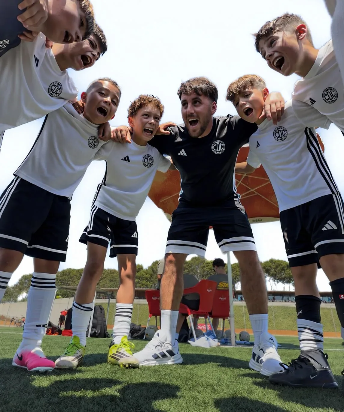 The squad in a huddle with their coach before training